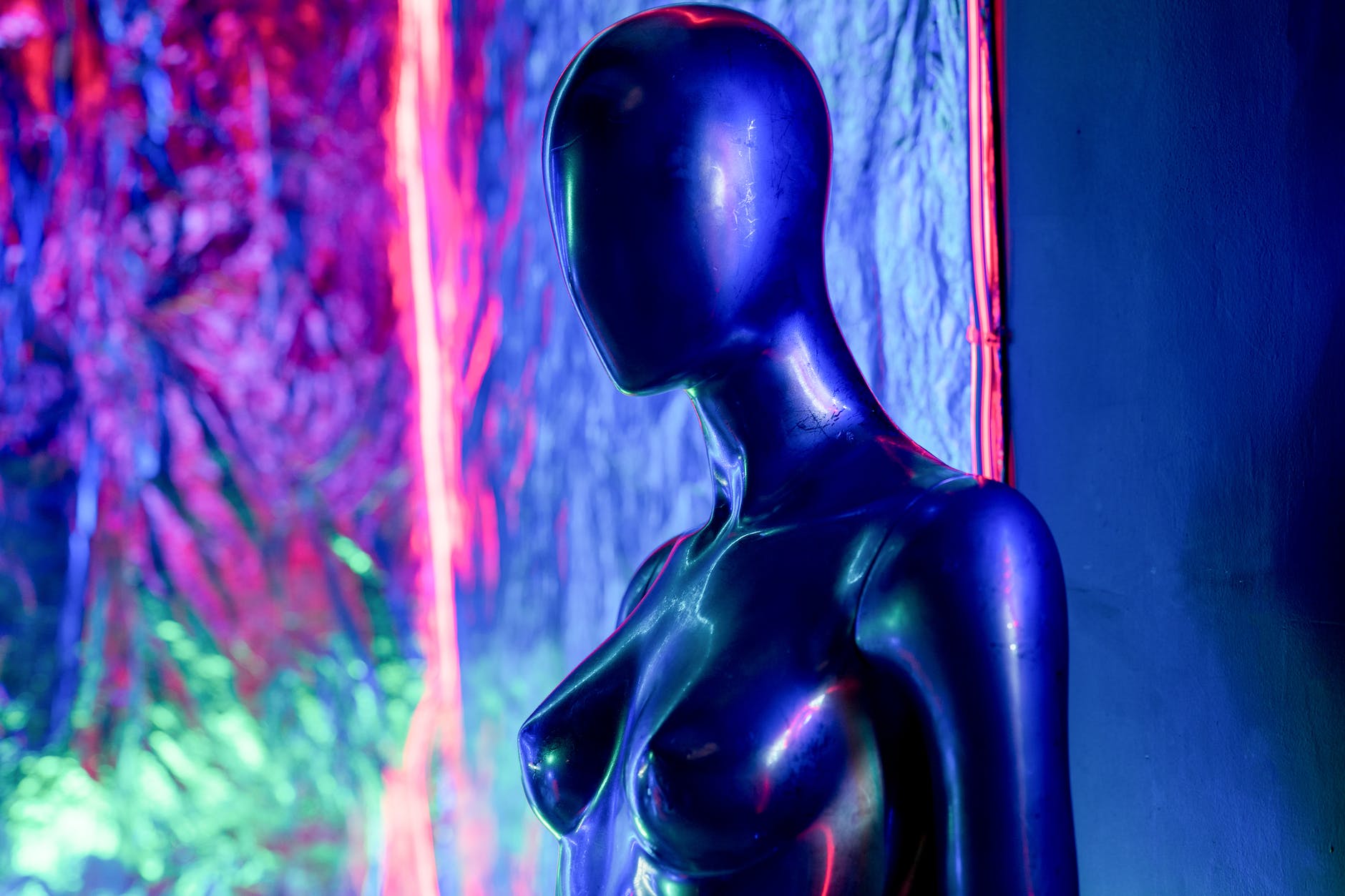 a mannequin in front of neon lights background