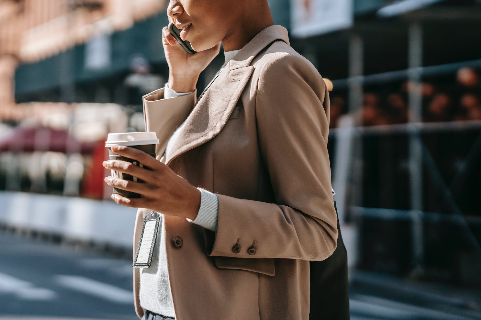 crop black businesswoman speaking on smartphone on street